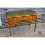 A late Victorian walnut writing table inset tooled and gilt green leather top over five drawers,