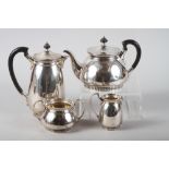 A silver four-piece teaset with gadrooned borders, ebonised finials and handles, 59oz troy approx