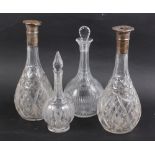 A pair of silver collared cut glass decanters, 11 1/2" high (damages) and two other cut glass