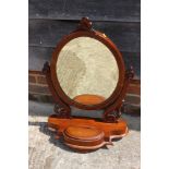 A 19th century mahogany swing frame oval dressing mirror, on plateau base, 29" high