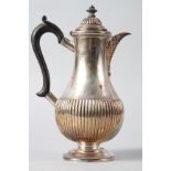 A silver hot water jug with half-fluted body and ebonised handle, 15.1oz troy approx