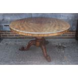 A Victorian figured mahogany scrub top circular dining table, on turned column and carved tripod