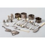 A selection of silver items, including decanter labels, napkin rings, two silver pepper shakers,