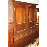 An 18th century oak wardrobe, the upper section enclosed two Gothic panel doors over two faux