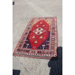 A pair of Konya tribal rugs with lamp design on a red ground and multi-star borders in shades of