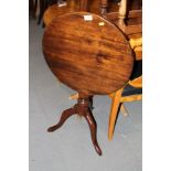 A 19th century mahogany circular tilt top wine table, on turned column and tripod splay support,