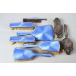 A silver and blue guilloche enamel six-piece dressing table set and two other silver backed dressing