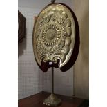 A late 19th century Arts & Crafts embossed brass firescreen with sunflower panel, on weighted