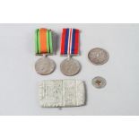 A WWII Defence Medal, another medal, an 1880 silver dollar and other items