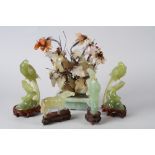 A pair of Chinese carved jade model birds, on hardwood stands, 7 1/2" overall (damages), a carved