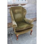 A late 19th century walnut framed wing armchair of early Georgian design with down loose seat