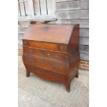 An early 19th century Continental oak bombe-shape fall front bureau, the upper section fitted