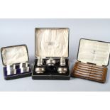 A silver five-piece cruet set, in fitted case, a set of four silver napkin rings, in fitted case,