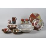 A studio pottery part service, comprising mugs, bowls, plates, jug and two larger bowls with