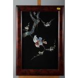 A pair of Oriental ebonised panels of birds on branches with inset mother-of-pearl and abalone, in