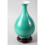 A Chinese oviform monochrome green glazed vase, on associated hardwood stand, 10 3/4" high