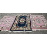 A pair of Chinese contour pile rugs with floral design on a pink ground, 62" x 36" approx, and a