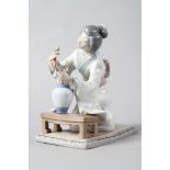 A Lladro figure of a Geisha arranging flowers in a vase, 7 3/4" high