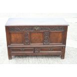 An early 18th century carved oak panel front mule chest, fitted two drawers, dated 1711, on stile