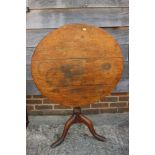 A Georgian provincial oak circular tilt top occasional table, on vase turned column and tripod splay