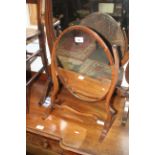 An Edwardian mahogany oval swing frame toilet mirror, on skeleton stand, 15" wide x 20" high