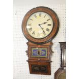 An American walnut and marquetry banded wall clock with white enamel dial and Roman numerals below
