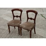 A pair of Victorian carved walnut balloon back chairs, upholstered in a corded fabric
