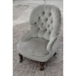 A 19th century low seat chair, button upholstered in a sage velour, on turned and castored supports