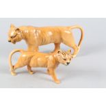 A Beswick lioness, 9" long, and a companion cub