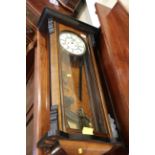 A walnut and ebonised Vienna clock with white enamel dial, 36 1/4" high, and another similar wall