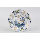 An early 18th century Bristol delft "Kraak" polychrome charger with bird and flower centre, 12 3/4"