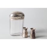A pair of silver pepperettes, formed as milk churns, and a silver topped dressing table jar, 2.3oz