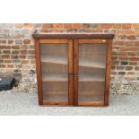 A pine wall cupboard enclosed two glazed doors, 32" wide x 10" deep x 32 1/2" high