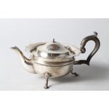 A silver squat teapot with waved rim and ebonised handle, on three cabriole supports, 12.7oz troy