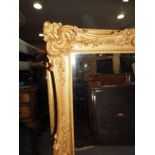 A bevel edged wall mirror, in shell decorated gilt swept frame, plate 22" x 36"