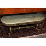 A gilt brass and onyx oval top coffee table, on pierced and moulded quatreform base, 45" wide