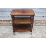 A mid Victorian rosewood three-tier service trolley with spindle sides, on turned supports, 26" wide