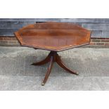 A mahogany and banded octagonal tilt top dining table, on turned column and quadruple splay supports