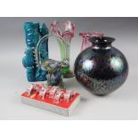 A spherical iridescent glass vase, two Victorian style ruby and green glass vases, a boxed set of