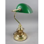 A brass desk lamp with green glass shade