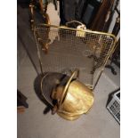 A brass coal scuttle, a coal shovel, a brass wire mesh firescreen and a brass standard lamp with
