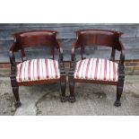 A pair of early 19th century design library chairs with deep curved shoulder boards, scroll arms, on