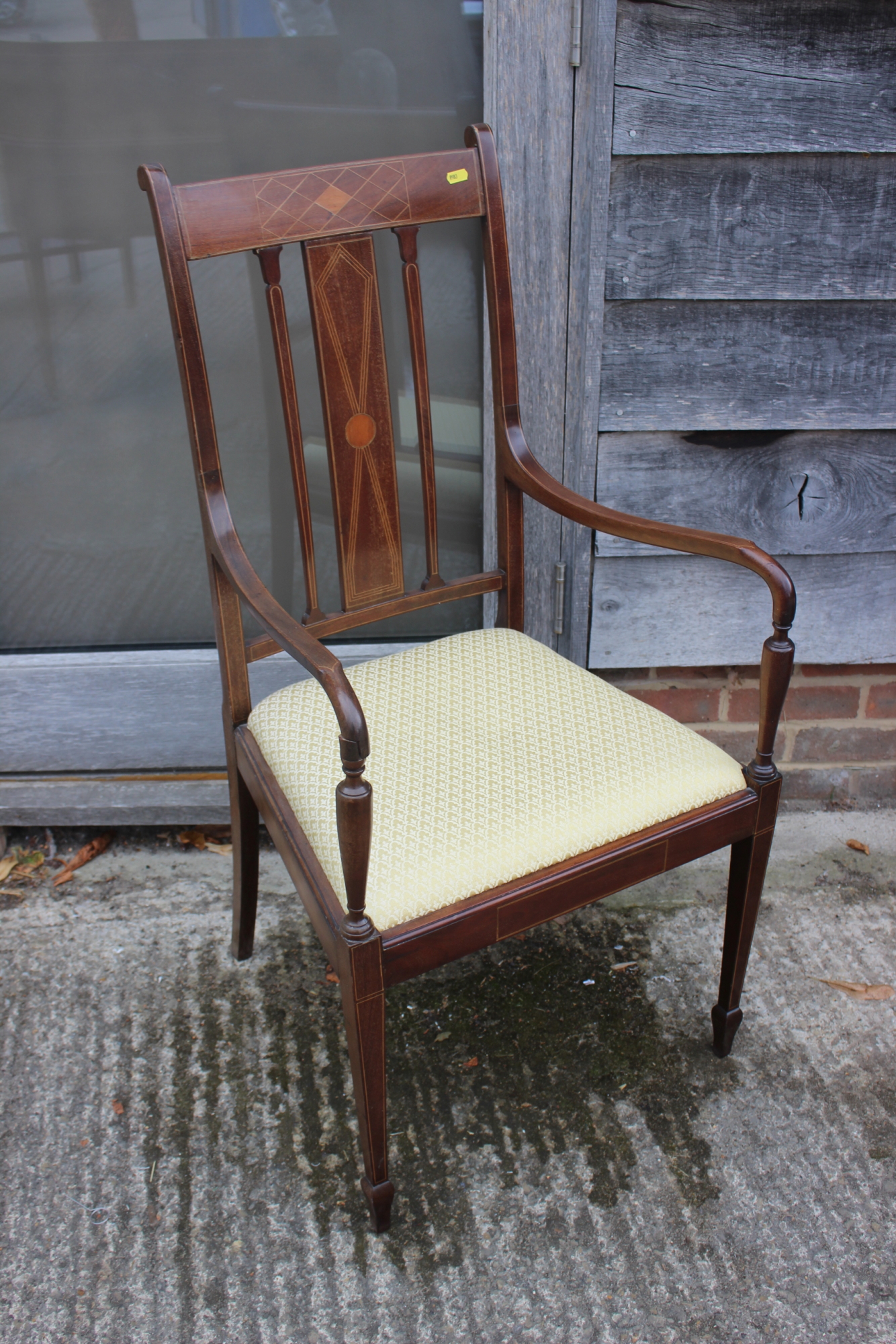 An Edwardian line inlaid mahogany open armchair with drop-in seat, upholstered in a gold fabric