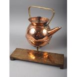A Benson style spherical copper kettle, on three feet, 9" high, and a brass cribbage board