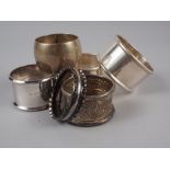 A pair of plain silver napkin rings and four other silver napkin rings, 5.6oz troy