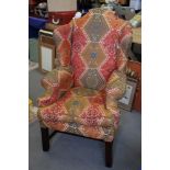 A George III design wing back armchair, upholstered in a Caucasian kelim design fabric