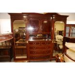An Edwardian plum pudding mahogany and satinwood banded break bowfront wardrobe, fitted central