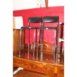 A pair of chrome framed bar stools with black seats and backs