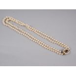A two-string graduated pearl necklace with 9ct gold, garnet and pearl clasp