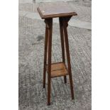 A late 19th century oak jardiniere stand, on splay supports, and an oak cupboard enclosed panel